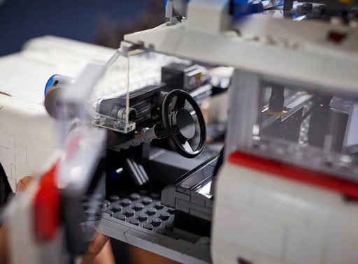 A close-up view of the interior of the LEGO Ghostbusters Ecto-1 (10274) model, with the driver’s side door open to reveal the detailed dashboard, steering wheel, and seats.