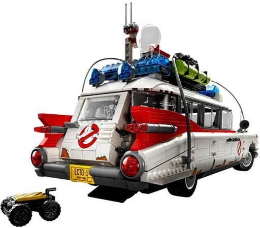 Rear view of the LEGO Ghostbusters Ecto-1 (10274) model, showcasing the detailed back section including the iconic Ghostbusters logo, functional ghost trap, and roof-mounted equipment. The model is positioned to highlight the vehicle’s tail fins and license plate, with the ghost trap accessory placed next to it on the ground.