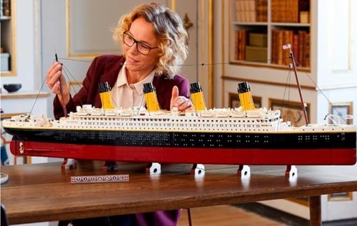 Person assembling the LEGO Creator Expert Titanic set, showcasing its detailed and realistic design.