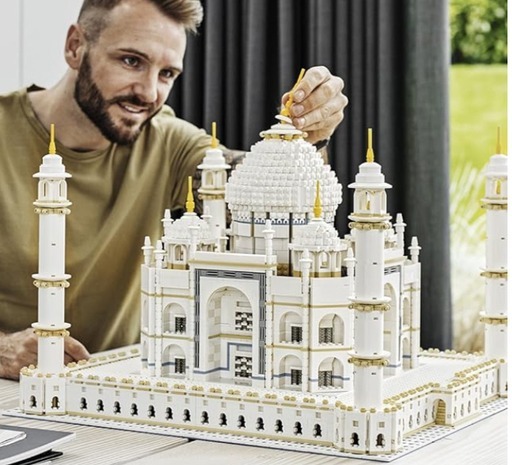 A man assembling the LEGO Creator Expert Taj Mahal 10256 set, showcasing the detailed architectural features and grandeur of the model.