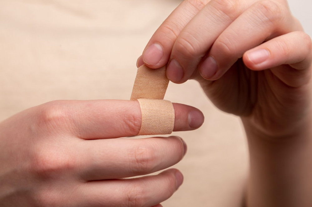 Photo of a person wrapping a bandage on a finger.counterfeit LEGO Sets.