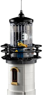 Image or the top of the Lego motorized lighthouse set with a minifigure stand on the top platform holding a telescope.