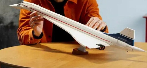 Photo image of the Lego Icons Concorde 10318, displayed on a table top with a person holding it upward