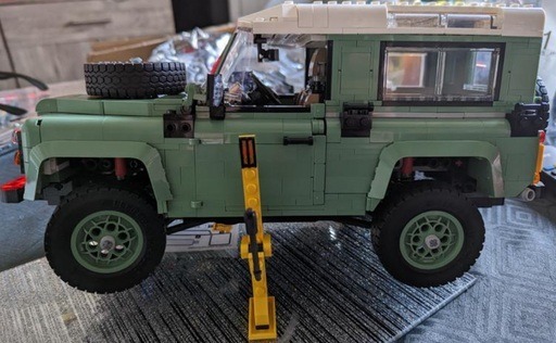 Image of the LEGO Icons Land Rover Classic Defender 90up on its jack changing a tire 