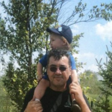 A father with his young child on his shoulders, both smiling in an outdoor setting with trees and a blue sky in the background. The image links to the post titled ‘About the Author: Lou’s Journey in LEGO Wonder,’ highlighting Lou’s deep-rooted passion for LEGO and his dedication to creating a vibrant community through Lou’s Bricks House, covering everything from LEGO set reviews to its use in education and therapeutic settings.